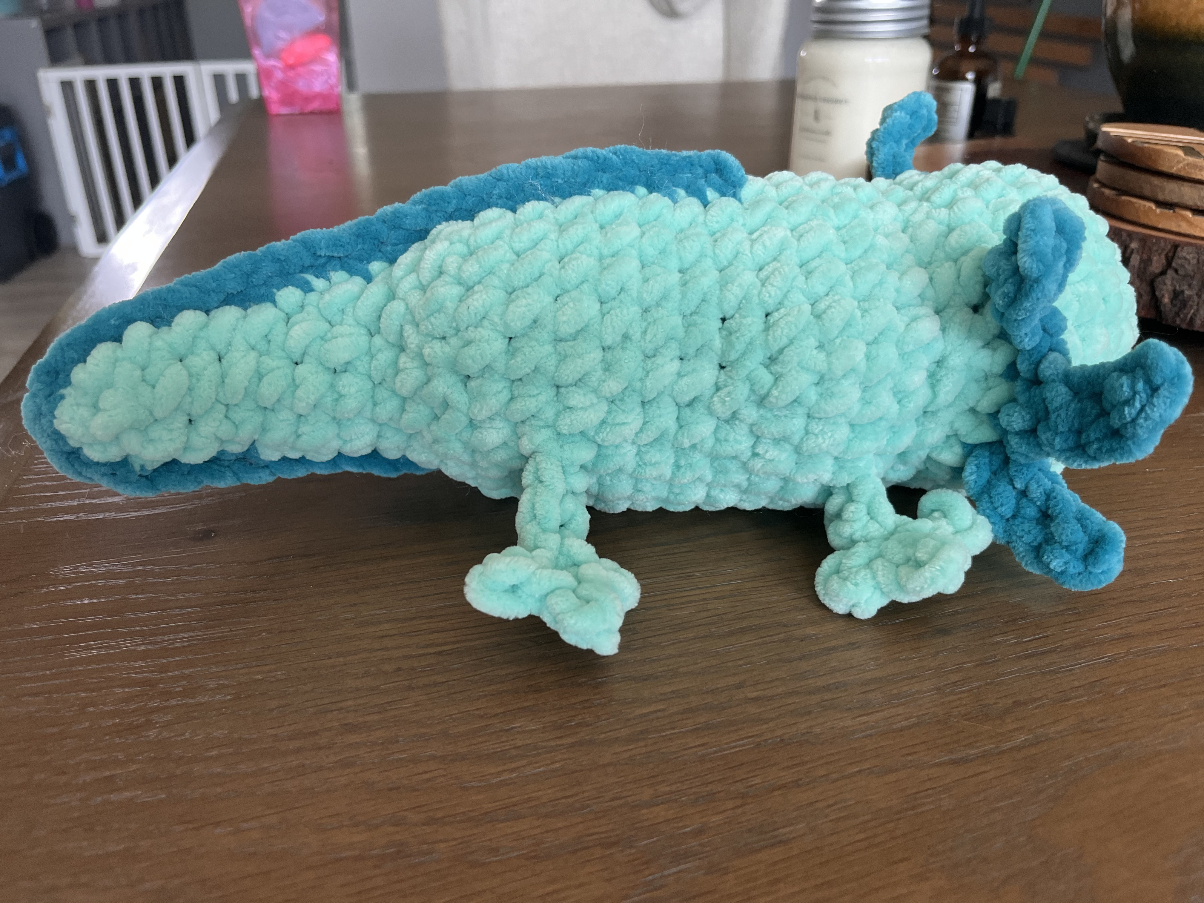 Right facing photo of a blue crocheted axolotl